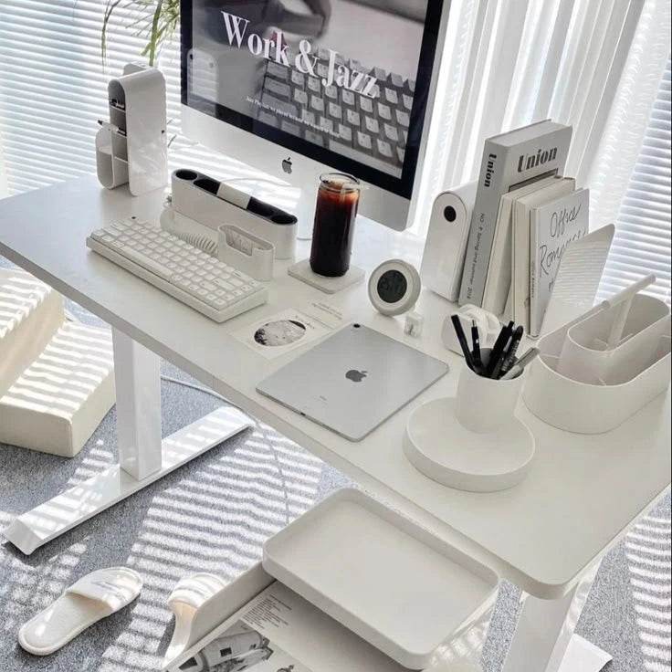 Modern minimalist workspace with white desk, computer, and stationery organized neatly, featuring 'Work & Jazz' on the screen.